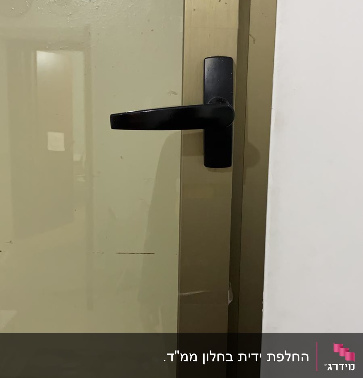 חלון עם מסגרת מתכת וידית שחורה